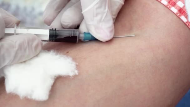 Medic i handskar sätter nålen i mans ven och ansluta provrör för blodprovstagning — Stockvideo
