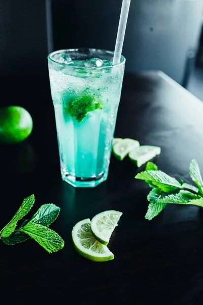 Beautiful Lemonade or Mojito coctail with lime, mint and ice, fresh drink on black table — Stock Photo, Image