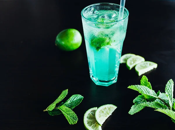 Fresh cocktail with basil, lemon and ice cubes. Homemade lemonade with lemon and basil — Stock Photo, Image