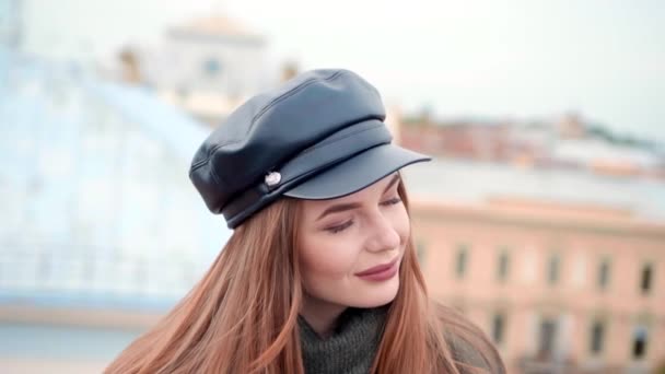 Primer plano del retrato al aire libre de otoño de la joven pelirroja chica bastante elegante posando en el techo. Vista de edificios y techos de la ciudad . — Vídeo de stock