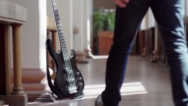 Mannen plockar upp gitarren från golvet — Stockvideo