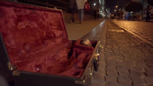 Saksofonista grający muzykę za pieniądze, futerał saksofonu otwarty na donacje. Street performerzy zarabiają na życie w miejscach publicznych w mieście. — Wideo stockowe