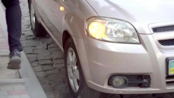 Jeune homme battu nerveux avec son pied dans la roue de voiture — Video