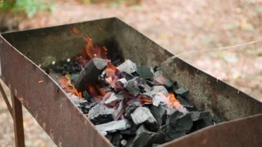 Close-up of burning coals in the barbecue grill. Coal is starting to burn. Slow motion video