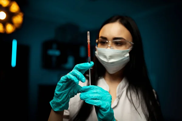 coronavirus epidemic from china. selective focus. woman doctor use syringe. nurse make injection in respirator mask. health worker dials vaccine in syringe. Physician or giving vaccine against virus