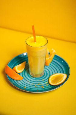 Taze sıkılmış portakal suyu, pipet ve portakal dilimi.