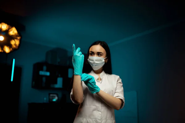 Koruyucu maske takan güzel bir kadın doktor ya da hemşire ya da laboratuvar arka planında kopyalanmış lastik eldiven. Sağlık hizmeti kavramı
