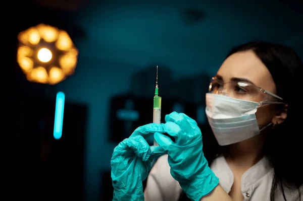 Doktor şırıngayı tutuyor ve iğneye hazırlanıyor. Kadın doktor elinde şırınga tutuyor. Hemşire ya da kadın doktor elinde iğne tutuyor.
