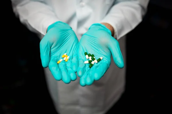 Лікарі тримають руки в блакитних медичних рукавичках з різнокольоровими таблетками. Медична концепція охорони здоров'я Ліцензійні Стокові Фото