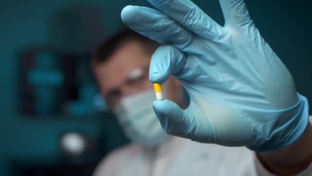 Extreme close-up of a male scientist analyzing a pill in the laboratory — Stock Video