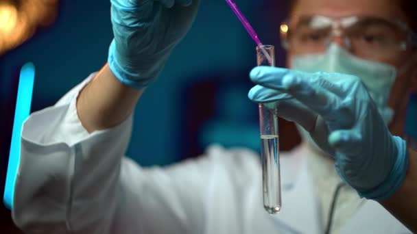 Fütüristik bir laboratuvarda, pipetli bir bilim adamı DNA 'yı ve test tüplerindeki molekülleri ayırmak için renkli bir sıvıyı analiz eder. — Stok video