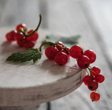 stand ahşap masa üzerinde kırmızı kuş üzümü