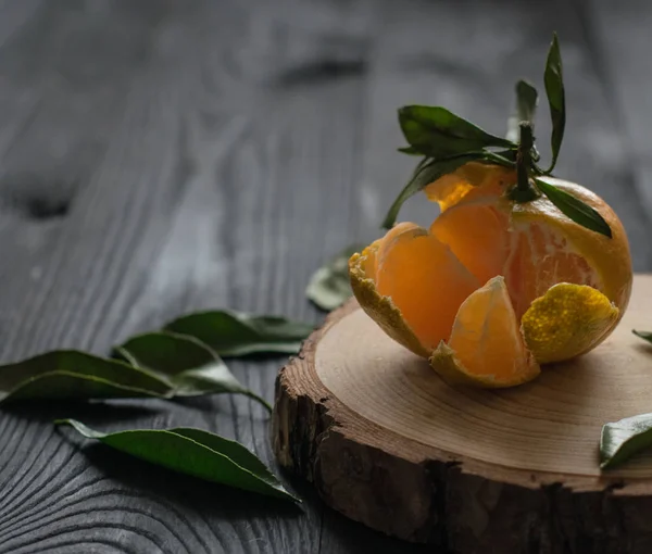 tangerine, leaf, black wood table,wood slice