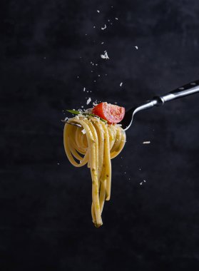 Domatesli tagliatelle ve çatallı pesto. İtalyan yemeği. Koyu arkaplan