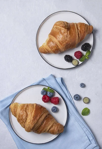 Two fresh  croissant on a white plate  with blueberries and raspberry — 스톡 사진
