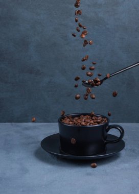 Kahve fincanında uçuşan aroma kahve çekirdekleri. Koyu arkaplan