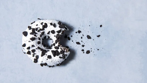 Uno delicioso fresco abundante blanco y negro mordido donut mentira sobre fondo blanco — Foto de Stock