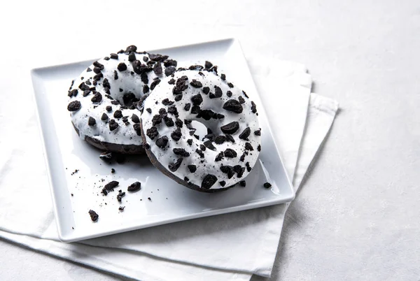 Dos deliciosas rosquillas frescas y abundantes en blanco y negro se encuentran sobre un fondo blanco . — Foto de Stock