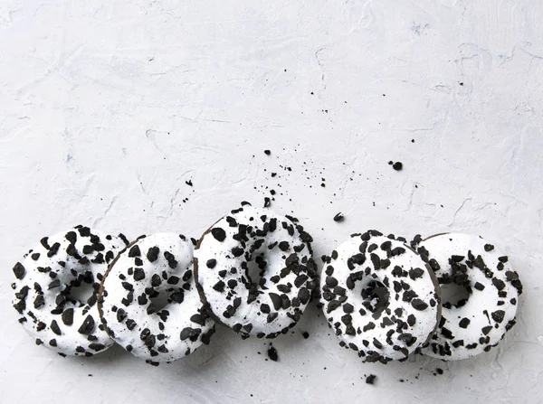 several delicious fresh hearty black and white doughnuts lie on a white background.