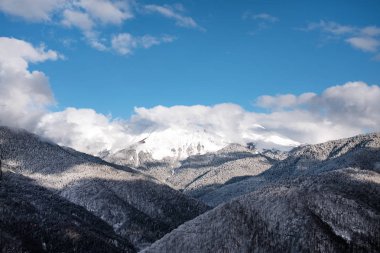 Soçi 'deki Rosa Khutor dağ kayak merkezi. Bulutlu, güneşli bir kış günü