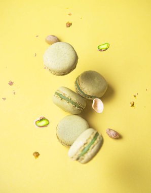 Fıstıklı ve sarı arka planda düşen lezzetli yeşil makarna. Üst görünüm ve yükselme