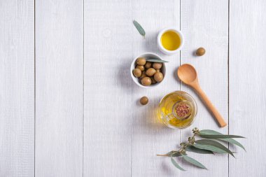 Beyaz ahşap bir arka planda, zeytinyağlı, olgun, çevre dostu zeytinler. Vejetaryen ve diyet ürünleri. Üst görünüm, düz görünüm ve boşluk kopyala