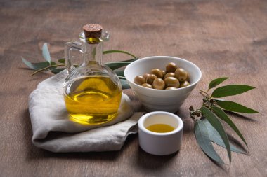 Kahverengi ahşap arka planda zeytinyağlı olgun doğal eko zeytinleri. Vegan ve diyet ürünü