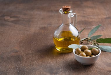 Kahverengi ahşap arka planda zeytinyağlı olgun doğal eko zeytinleri. Vegan ve diyet ürünü