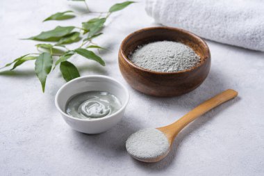 Kozmetik yeşil kilden yapılmış maske gri beton arka planda bir ahşap kasede. Kendi kozmetolojistim..