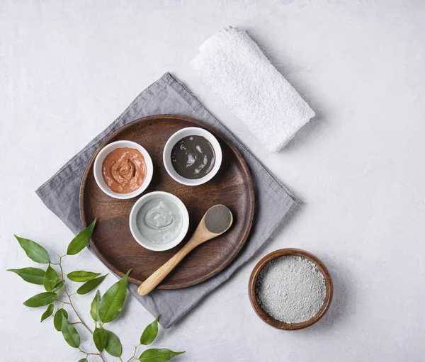 several types of cosmetic clay  pink, green and gray with lavender on a gray concrete background. Home cosmetologist. Top view, flat lay and copy space.