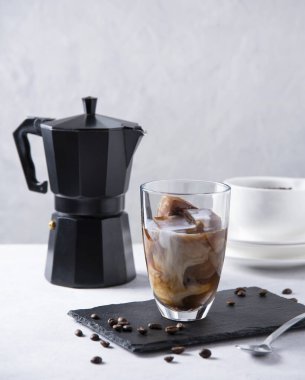 Gri masada bir bardak soğuk, ferahlatıcı vejetaryen buzlu kahve. diyet ürünü