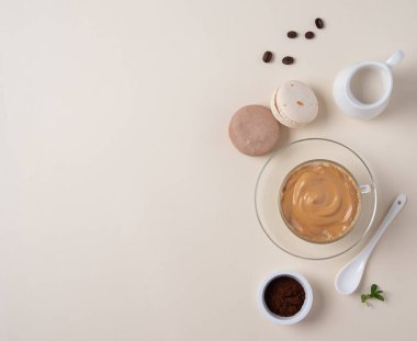  Bardakta Kore dalgona kahvesi, badem kurabiyesi, kahve çekirdeği ve açık sarı arka planda süt sürahisi. Moda içeceği. Üst görünüm, düz görünüm ve kopyalama alanı