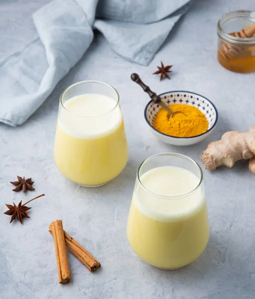 two glasses of Golden milk with turmeric  and honey on blue background. strengthens the immune system drink.  Close up