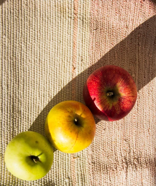 三个天然的乡村苹果躺在桌布上. — 图库照片
