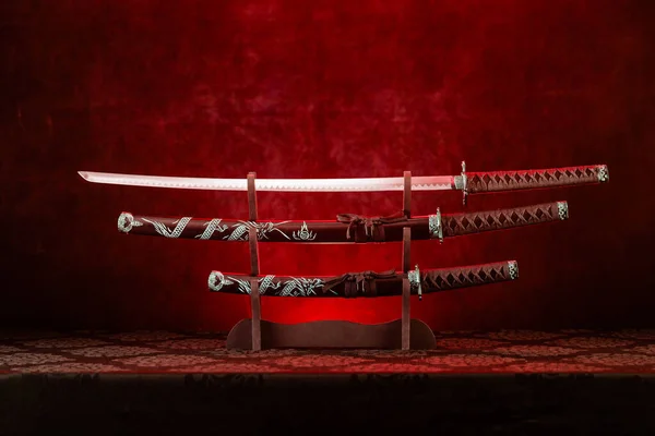 Three Swords Stand Katana Blade Exposed Red Light Stock Picture