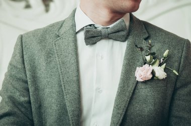 Bir damat gri renk takımlı ve beyaz gömlek olay için hazırlanıyor