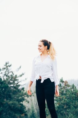 oldukça genç bir kadın gülümsüyor, gözleri kapalı Tepesi üzerinde