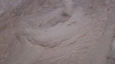 Büyük bir konteynırın içine macunu karıştır. Yapım işleri için elektrikli dikey el karıştırıcısı kullanarak macunu harmanlamak  