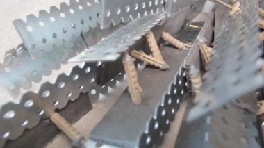 Yerde asılı duran metal profil yığınına dolly hareketini kapat. İnşaat halindeki bir evde alçı taşı yerleştirme hazırlığı
