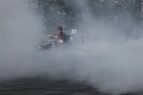 Carro à deriva e menina em fumaça — Fotografia de Stock