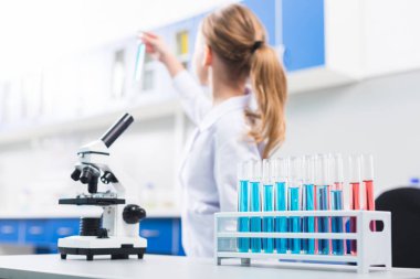 Laboratuvar lar. Profesyonel mikroskobun seçici odağı ve reaktiflerle dolu ve yanına koyarak küçük şeffaf şişeler