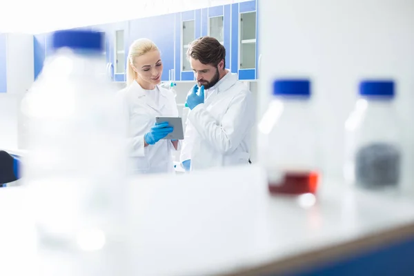 Smart nice scientist looking at the tablet screen — Stock Photo, Image