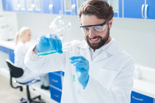 Feliz hombre encantado trabajando con reactivos químicos — Foto de Stock