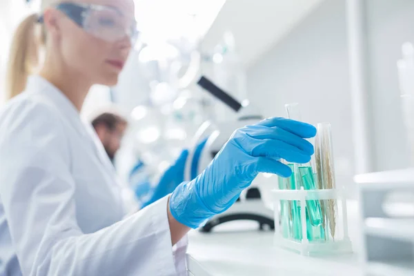 Selective focus of a female hand taking a test tube — Stock Photo, Image