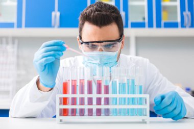 Tam konsantrasyon. Esmer profesyonel erkek laboratorian onlar stand yerleştirerek şişelerde sıvı bırakarak için pipet ile çalışan