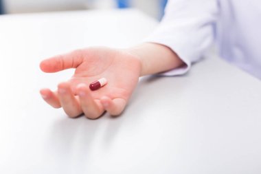 Tıbbi tedavi. Olumlu bir neşeli güzel çocuk elinde olmak bir hap yakın