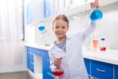 En sevdiğim bilim. Pozitif mutlu mutlu kız gülümseyen ve kimyasal laboratuvarda iken şişeleri tutarak