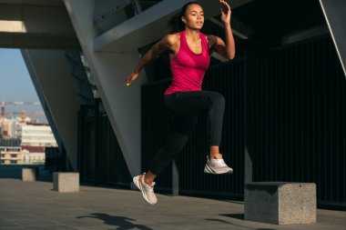 Havadaki coşkulu sporcu kadın sıçrama sırasında hareket halinde.