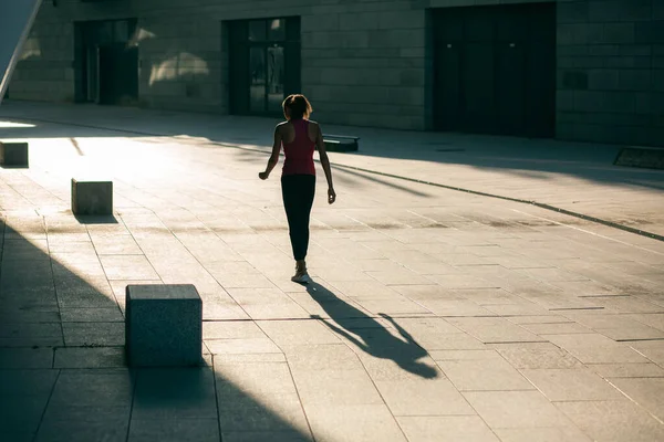 Rare view of a sportswoman walking alone in the street while returning after training