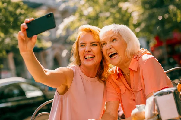 Mulher Adulta Sorrindo Tirando Selfies Emocionantes Com Sua Mãe Idosa — Fotografia de Stock